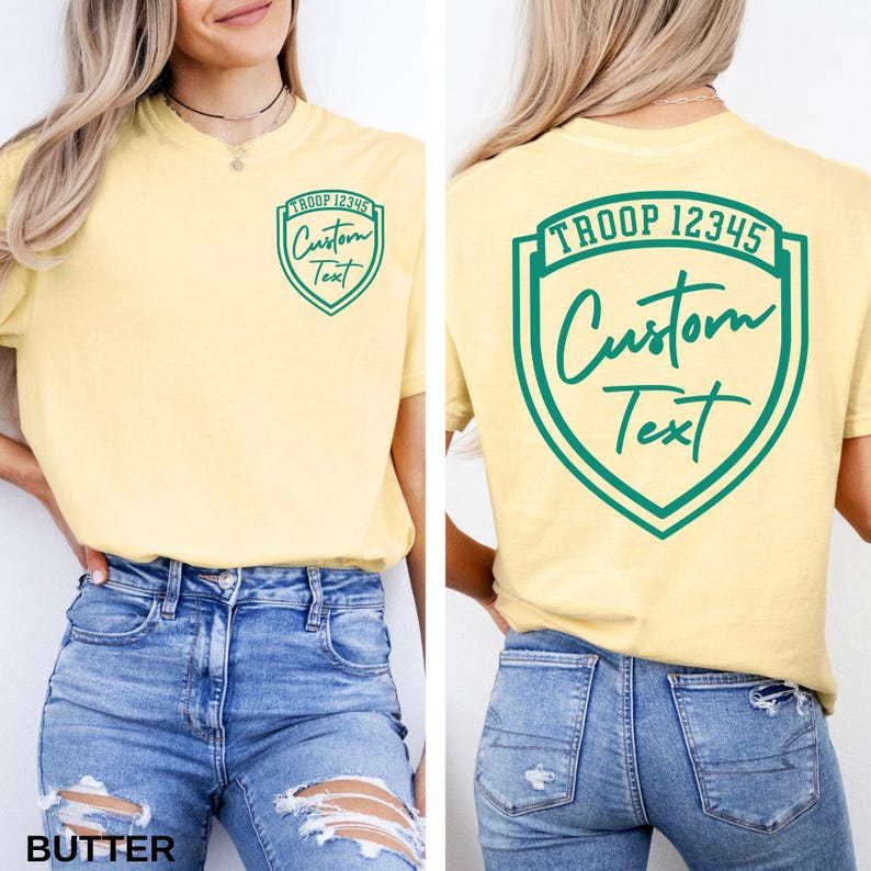 A woman wearing a yellow t-shirt with a green shield-shaped logo on the back, and a yellow t-shirt with a green shield-shaped logo on the front.