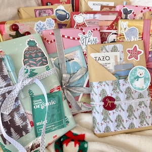 May include: A collection of wrapped gifts with decorative stickers and ribbons. The gifts are wrapped in various festive papers, including red, pink, and green patterns. Some gifts have stickers with winter and holiday themes.