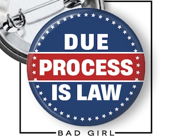 Pode incluir: Um broche circular com fundo azul escuro e uma faixa horizontal vermelha no centro. O texto DUE PROCESS IS LAW está impresso em letras maiúsculas brancas em negrito. Uma borda de pequenas estrelas brancas circunda todo o design.