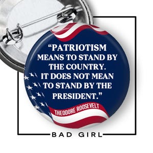 May include: A round pinback button featuring a dark blue background with a red and white American flag design. The text reads: "PATRIOTISM MEANS TO STAND BY THE COUNTRY. IT DOES NOT MEAN TO STAND BY THE PRESIDENT." and "THEODORE ROOSEVELT" in white.