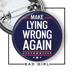 May include: A circular pin-back button with a dark blue background and white text that reads MAKE LYING WRONG AGAIN. The design includes two horizontal red lines above the text and a red stripe with white stars below the text. The back is silver metal.