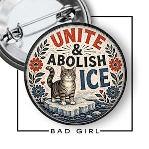 May include: A round pinback button featuring a brown tabby cat standing on an ice floe. The text reads UNITE & ABOLISH ICE in red and blue lettering. The design includes floral accents in red and blue, with a metal pin mechanism on the back.