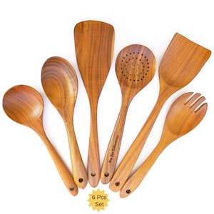 May include: A set of six wooden kitchen utensils, including a spoon, spatula, slotted spoon, and fork. The utensils are made of light brown wood and have a natural finish. The set is labeled "6 Pcs Set".
