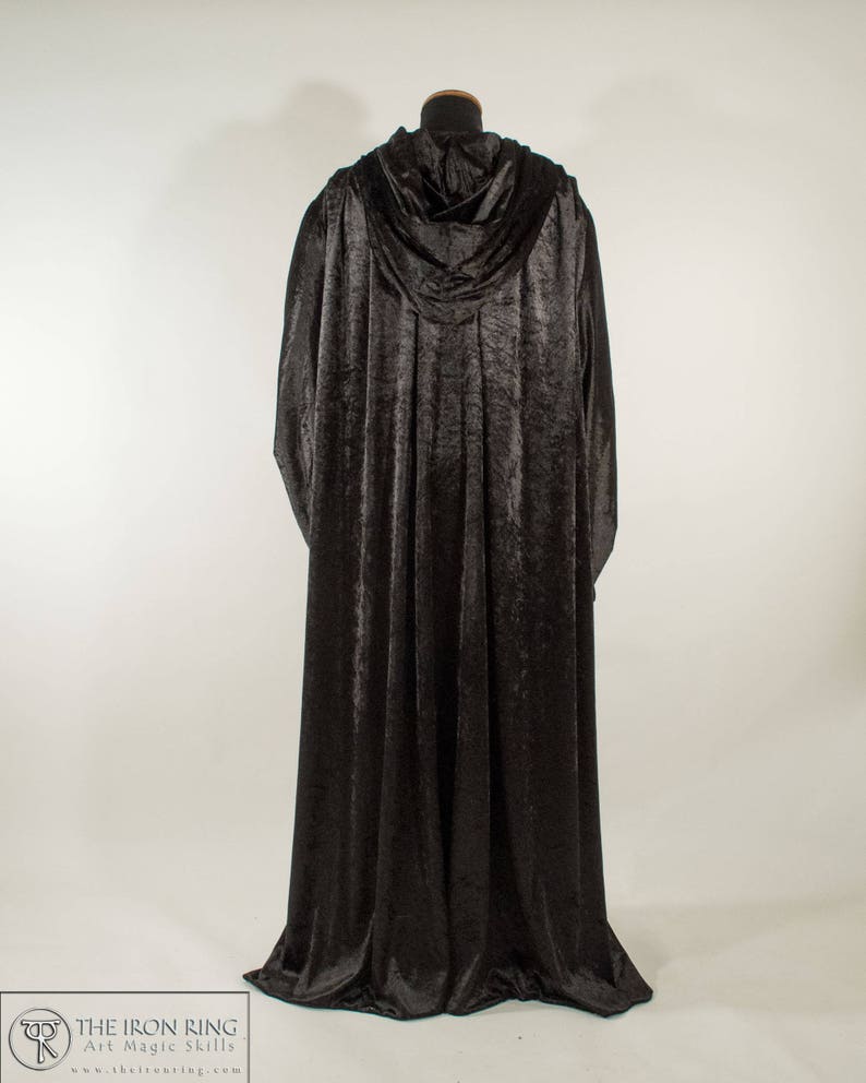 May include: A black velvet hooded cloak with a long flowing design. The cloak is made of a soft, luxurious fabric and has a classic, elegant style.