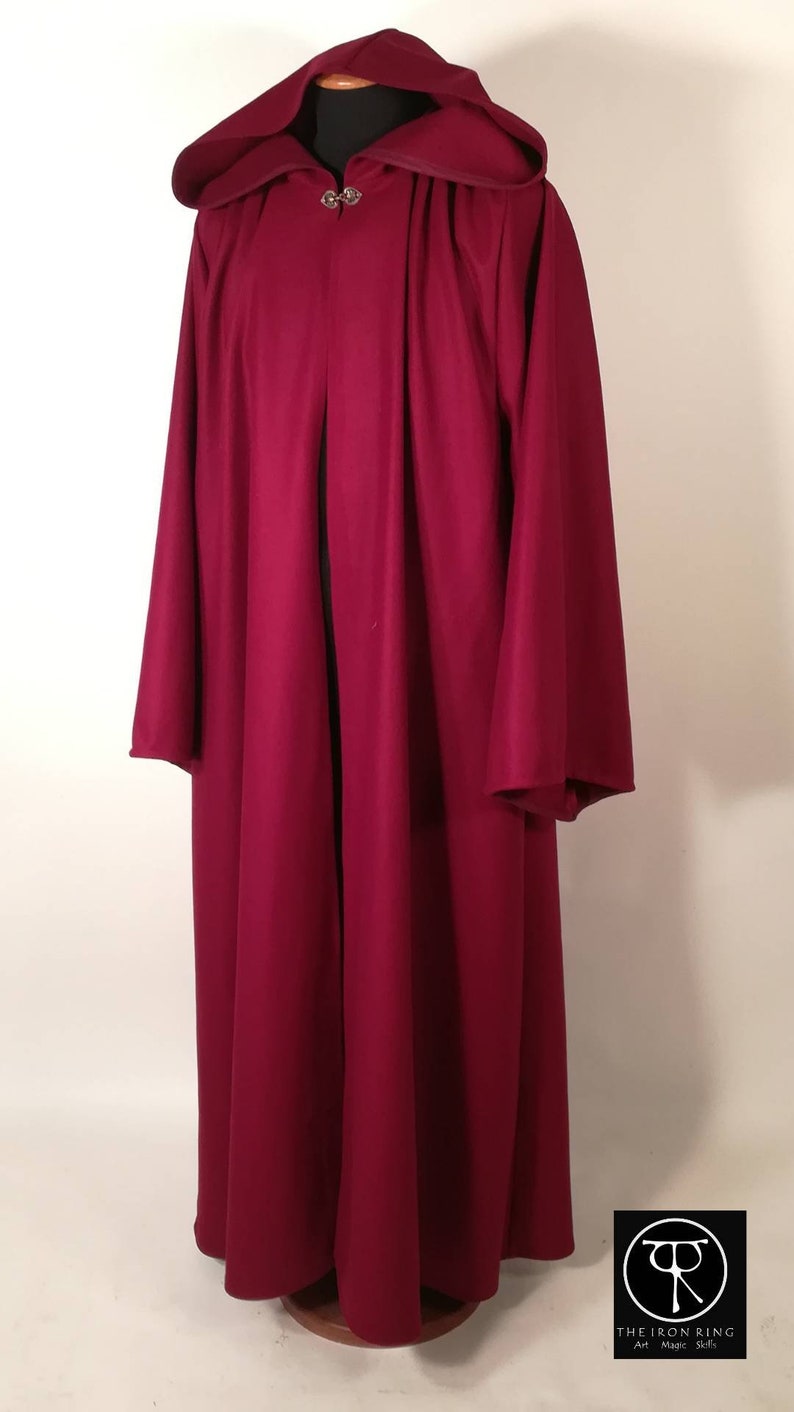 May include: A long, burgundy hooded robe with a silver clasp at the neck. The robe is made of a soft, flowing fabric and has a simple, elegant design.