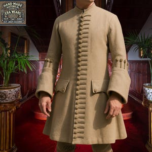 May include: A tan historical coat with a mandarin collar, button detailing, and flared sleeves. The coat features two front pockets and decorative buttons down the front. The image includes a logo that says "HAND-MADE HISTORICAL ERA WEARS".