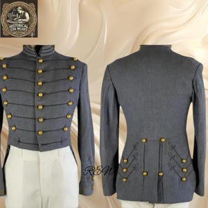 Puede incluir: Chaqueta gris de estilo militar con botones dorados y ribetes negros. La chaqueta tiene cuello alto y mangas largas. La parte trasera de la chaqueta presenta costuras decorativas y más botones dorados. La chaqueta se combina con pantalones blancos.