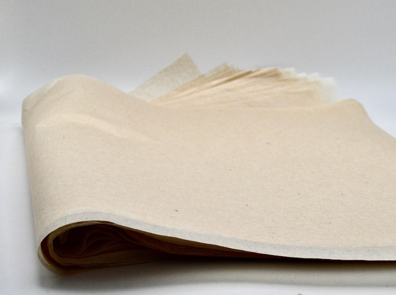 May include: A stack of off-white tissue paper, folded and ready for use. The paper is smooth and has a slightly textured surface.