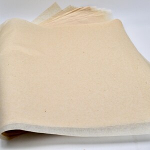 May include: A stack of beige tissue paper with a white edge. The paper is slightly crinkled and has a natural texture.