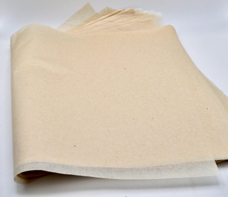 May include: A stack of beige tissue paper with a white edge. The paper is slightly crinkled and has a natural texture.
