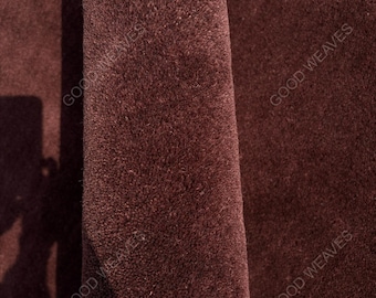 May include: A dark brown, plush, textured fabric surface with a folded edge. The text GOOD WEAVES is visible in multiple locations across the material, indicating the brand name on this deep brown, soft, and dense textile material.