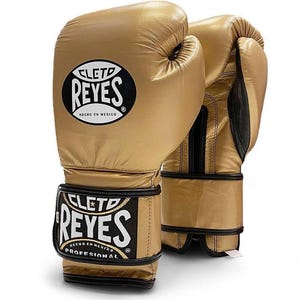 May include: Pair of gold boxing gloves with black trim and the Cleto Reyes logo. The gloves have the text "HECHO EN MEXICO" and "PROFESSIONAL" on them.