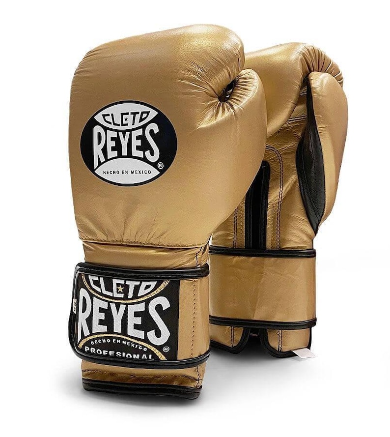 May include: Pair of gold boxing gloves with black trim and the Cleto Reyes logo. The gloves have the text "HECHO EN MEXICO" and "PROFESSIONAL" on them.