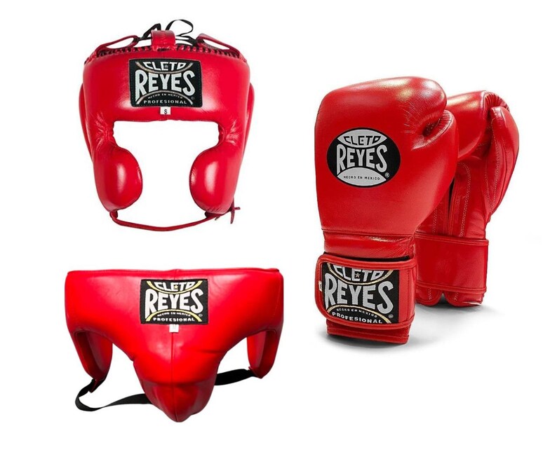 May include: Red boxing headgear, gloves, and groin protector set. The headgear has ear and cheek protection. The gloves are designed for boxing. The groin protector has a black strap. All items have the "REYES" logo.