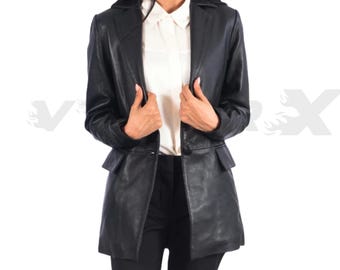 May include: A black leather blazer with a notched collar and two front pockets. The blazer is worn over a white collared shirt and black pants. The jacket has a classic, tailored design.