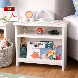 May include: White nightstand with a striped top, holding a pink and yellow clock, toys, and books. The books include "Little Miss Fun" and "Cat in the Hat". A PDF icon is in the upper left corner.