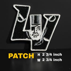 Puede incluir: Parche bordado en blanco y negro con un diseño estilizado. El parche presenta una figura con sombrero y el texto "PATCH". El parche mide 7 cm de alto y 7 cm de ancho.