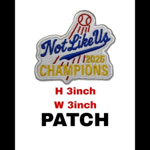 以下が含まれることがあります： 青い筆記体で「Not Like Us」、黄色で「Champions」と書かれた刺繍パッチ。上部には赤い野球のグラフィックがあります。パッチの高さは7.6cm、幅は7.6cmです。「PATCH」という文字が下に印刷されています。