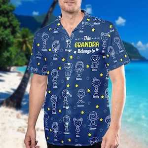 May include: Navy blue button-down shirt featuring a pattern of stick figures, stars, and dog illustrations. The shirt has the text "This Grandpa Belongs to" with names. A personalized gift for a grandfather.