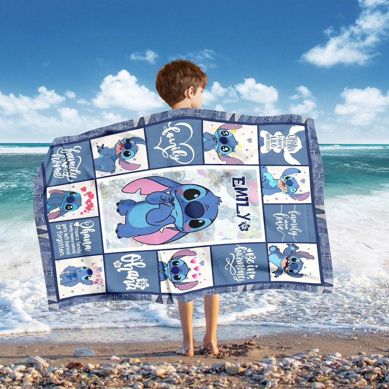 May include: A blue and white blanket featuring the character Stitch from Lilo & Stitch. The blanket has a grid pattern with Stitch illustrations and the name "EMILY". Phrases like "Ohana means family" are also visible.