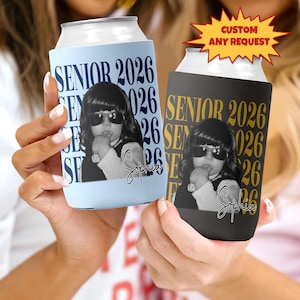 May include: Two personalized can coolers, one light blue and one black, each featuring a photo of a child wearing sunglasses. The text "SENIOR 2026" and the name "Sophia" are printed on each cooler. A yellow starburst graphic reads "CUSTOM ANY REQUEST".