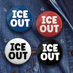 May include: Four round buttons with the text "ICE OUT" in bold white letters. The buttons are in the colors blue, red, black, and white. The buttons are on a denim background.