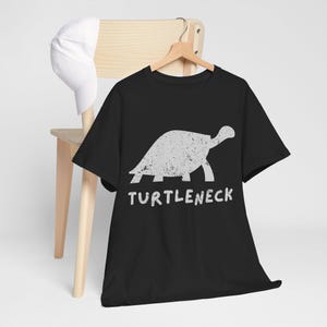 May include: Black t-shirt with a white graphic of a turtle walking and the text "TURTLENECK" underneath.