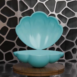 May include: Two-piece, light blue decorative bowls with a scalloped edge design. The bowls are displayed on a round, wooden table. The background features a metallic, geometric pattern.