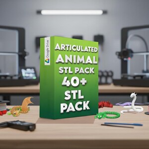 May include: A green box with the text "ARTICULATED ANIMAL STL PACK 40+ STL PACK" stands on a wooden table. Several 3D-printed articulated animal models are scattered around the box, including a dragon, a turtle, and a snake. The Google Drive logo is visible.