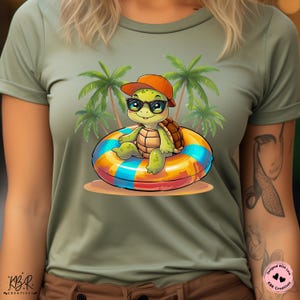 May include: A green turtle wearing sunglasses and a red hat floats in a colorful inflatable ring. The turtle is surrounded by palm trees on a green t-shirt.