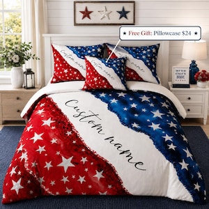 May include: A bedding set featuring a red, white, and blue star pattern with a diagonal design. The duvet cover and pillowcases include the text Custom name in black script. The set includes two large pillowcases and one smaller square pillow.