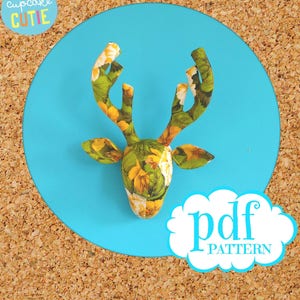 May include: A PDF pattern for a deer head with a floral print. The deer head is on a blue background with the text "pdf pattern" in a white cloud.