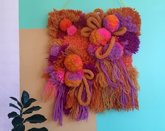 Mustard, pink and purple fiber art wall hanging. Latch hook, pom poms, knitting, punch needle, woven.