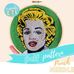 Puede incluir: Un patr&oacute;n PDF para un proyecto de bordado con aguja de punz&oacute;n que presenta un retrato de Marilyn Monroe. El patr&oacute;n est&aacute; en un aro verde con una imagen amarilla y blanca de Marilyn Monroe.
