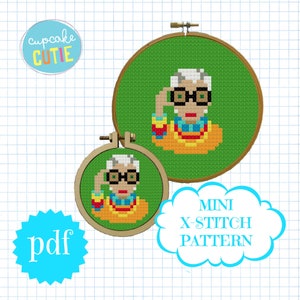 May include: A digital download pattern for a mini cross stitch project featuring a portrait of a woman wearing glasses and a colorful necklace. The pattern is available in PDF format.