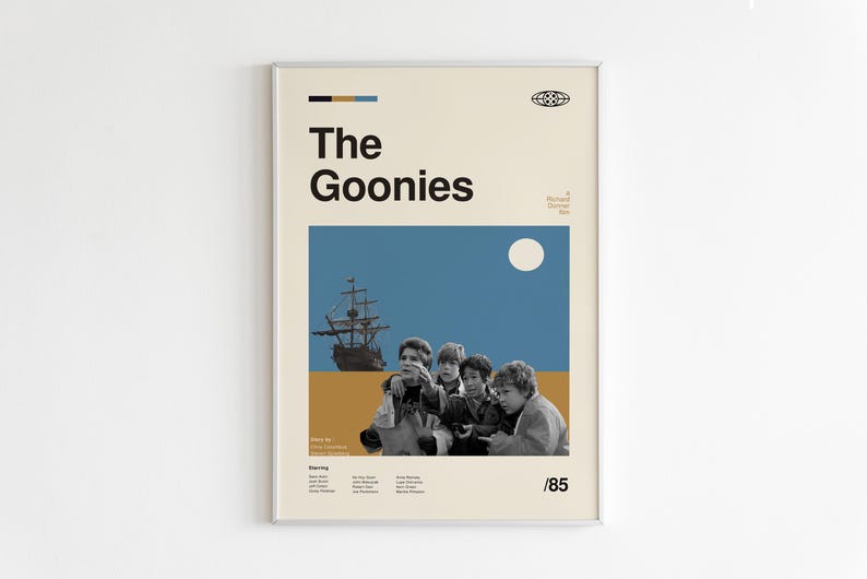 May include: A vintage-style poster for the film "The Goonies", featuring a group of children looking out at a ship sailing on a blue sea with a yellow beach in the foreground. The poster has a white background with a black title and a yellow and blue colour scheme.