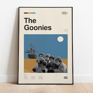 May include: A vintage-style poster for the film "The Goonies", featuring a group of kids looking out at a ship sailing on a blue sea with a white moon in the sky. The poster is in a black frame and has the text "The Goonies" in bold black letters.