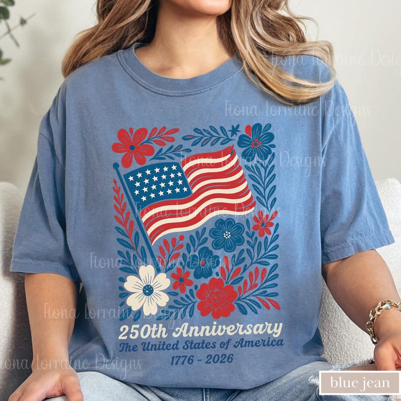 Puede incluir: Camiseta azul vaquero con un dise&ntilde;o patri&oacute;tico. El gr&aacute;fico incluye la bandera estadounidense, flores rojas y azules, y el texto "250th Anniversary The United States of America 1776-2026".