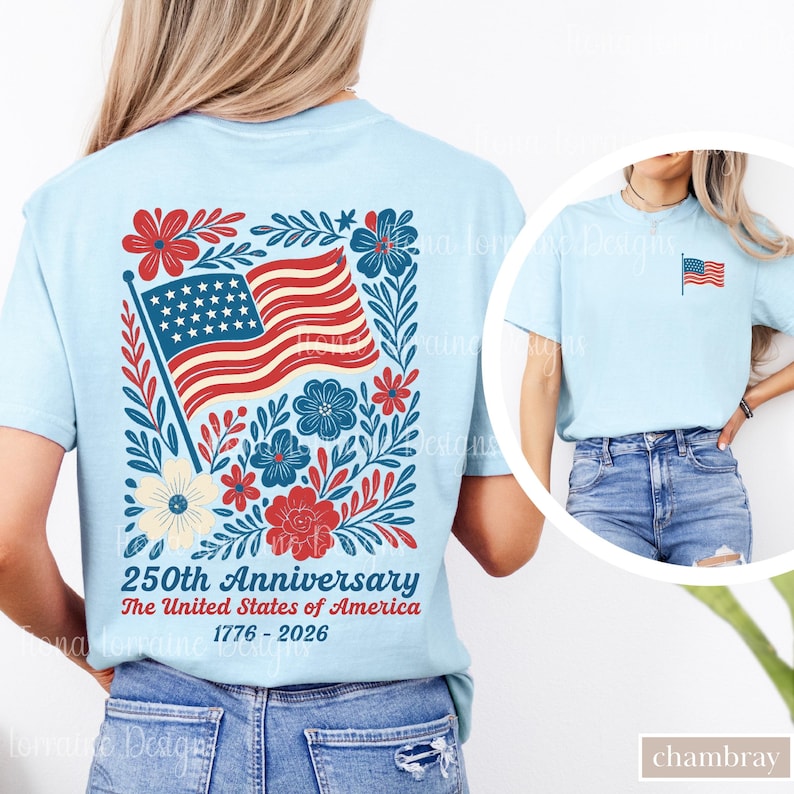 May include: Light blue t-shirt featuring a patriotic design. The back of the shirt displays an American flag with floral accents and the text "250th Anniversary The United States of America 1776-2026." A smaller flag is on the front.