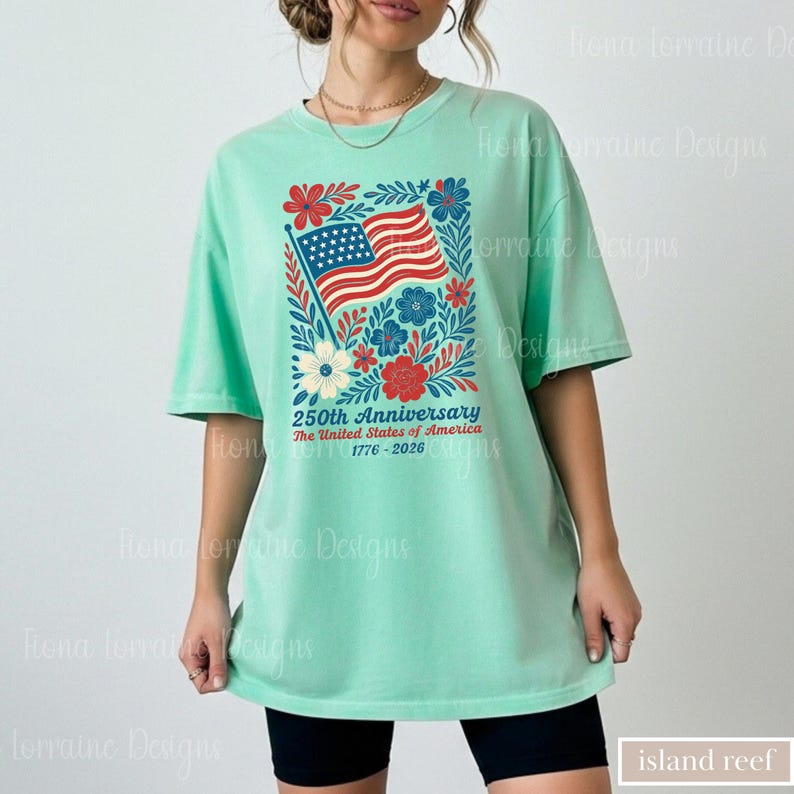 Puede incluir: Camiseta verde menta con un dise&ntilde;o floral que incorpora una bandera estadounidense y el texto "250th Anniversary The United States of America 1776-2026". El dise&ntilde;o incluye flores y hojas rojas, blancas y azules.