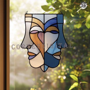 Könnte beinhalten: Buntglasfenster mit zwei stilisierten Gesichtern in einem symmetrischen Design. Das Kunstwerk verwendet Blau-, Orange- und Neutraltöne mit schwarzen Umrissen. Eine kleine Metallschlaufe ermöglicht das Aufhängen. Der Text "CORTE SDIGITAL" ist sichtbar. Geeignet für ein Fenster.