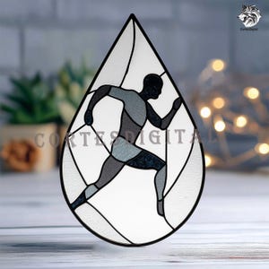 May include: Stained glass art piece in a teardrop shape, featuring a running figure in shades of gray and black. The design is outlined in black, with the text "CORTES DIGITAL" visible. The background is a mix of clear and textured glass.