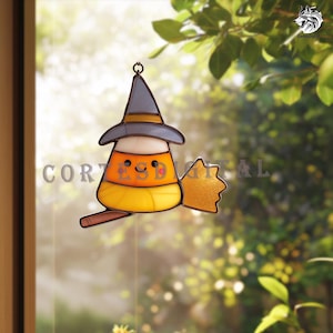 May include: A stained glass Halloween decoration shaped like a candy corn witch. The candy corn witch has a gray witch hat, a smiling face, and a broom. The decoration is hanging in front of a window with a blurred background.
