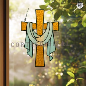 Puede incluir: Cruz de vidriera en amarillo dorado, con tela azul claro drapeada. La cruz está suspendida por cadenas y presenta el texto "CORTES DIGITAL". Ideal para decoración religiosa.