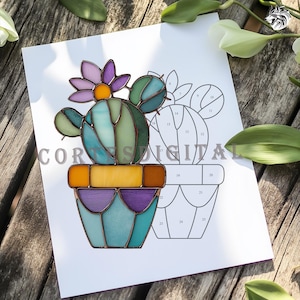 May include: A stained glass cactus design in a pot, featuring shades of green, blue, purple, and yellow. The cactus has a purple flower with an orange center. The image is on a white paper with the text "COR...DIGITAL".