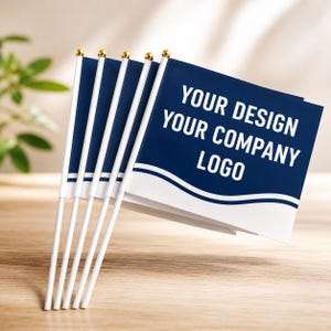 May include: A set of five small handheld flags on white plastic poles with gold-coloured ball finials. The flags are dark blue with a white wavy line at the bottom and feature the white text YOUR DESIGN YOUR COMPANY LOGO printed on the front.
