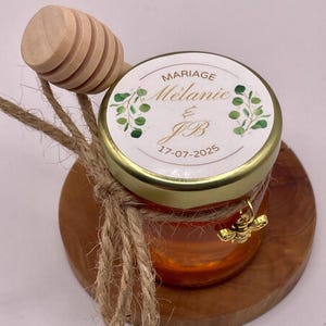 Miele - Bomboniere per matrimoni. Piccoli vasetti di miele personalizzati, accompagnati da un mestolo e un ciondolo a forma di ape dorata.