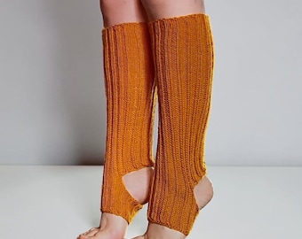 May include: A pair of mustard yellow, ribbed knit leg warmers that extend from the mid-calf down to the ankle. These leg warmers feature an open heel design, leaving the heel and toes exposed while covering the lower leg with a textured knit pattern.