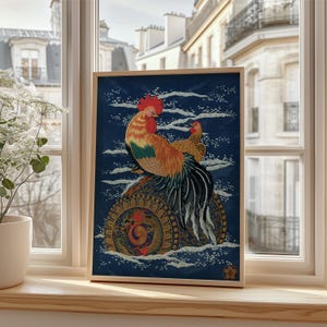 Puede incluir: Obra de arte enmarcada que presenta un gallo y una gallina en colores vibrantes sobre un fondo azul oscuro. El gallo tiene plumaje rojo, naranja y verde, mientras que la gallina es marrón. La obra está en un marco de madera, expuesta en un alféizar.