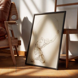 Puede incluir: Una impresi&oacute;n enmarcada que presenta un boceto de Atlas, una figura mitol&oacute;gica, sosteniendo un gran objeto circular. La obra de arte est&aacute; en un marco negro y se apoya en una estanter&iacute;a de madera. La imagen est&aacute; sobre un suelo de madera, con una silla de cuero en el fondo.